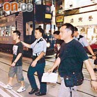 被捕男子（左）由警員帶走。