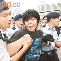 三男一女示威者在馬路靜坐，十分鐘後已被抬走。