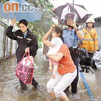 消防員及警員在洪水橋協助村民疏散。