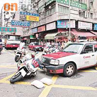 的士在十字路口撞翻交通警員電單車。