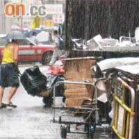 14:55<br>清潔工在大廈內取出一袋袋垃圾放上手推車。