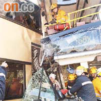 消防員努力搶救被困車長及上層乘客。