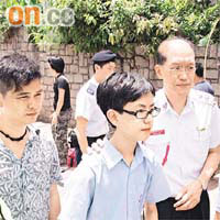 高級助理救護總長陳兆君（右）搭膊安慰老翁的外孫。