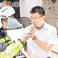 警員為肇事司機進行酒精呼氣測試。