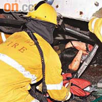 消防員用工具墊高車身拯救女傷者。