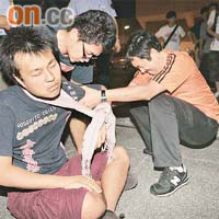 球賽後有學生不慎跌倒肩膊甩骹，沈祖堯（右）即時為受傷學生檢查傷勢及護送他上救護車。