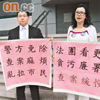 女被告林依麗（右）和男被告何家權（左）在庭外舉牌抗議。