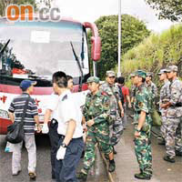 旅遊巴士上的駐港解放軍落車協助學生轉車。