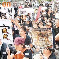 參加集會的市民自製「狗官」標語，諷刺當局濫殺流浪狗。
