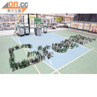 「玻璃再生璀璨」計劃的開幕禮上，協會用廢玻璃酒樽堆上「Green HK」字句。