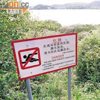 泥灘旁豎立切勿游泳的警告牌。
