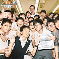 星級狀元朱志豪（手持成績單者）獲大批同學祝賀。