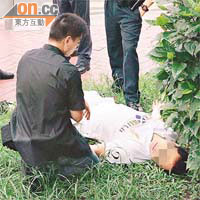 醉酒司機在草地昏睡，警員一臉無奈。