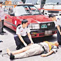 被的士撞傷保安員由救護員檢查傷勢。