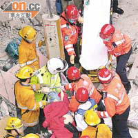 從塌樓當日的新聞圖片所見，救護員（紅帽者）與消防員一樣深入災場勇救傷者。(資料圖片)