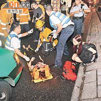 救護員搶救女傷者，同行女友人在旁打氣。
