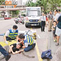 受重傷老婦倒臥地上，救護員為她急救。
