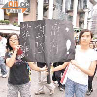 袁同學（左）高舉黑底白字的紙牌，狠批菲政府由救人以至善後表現差勁。