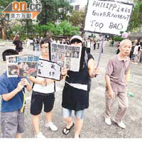 黎太（中）帶同兒子及姪女，手持剪報遊行。
