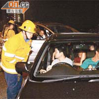 救援人員向私家車司機了解情況。