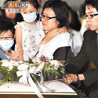 傅卓仁的靈柩運返本港時，其妻帶同一對子女在機場迎靈，場面傷感。		（資料圖片）
