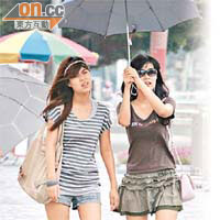 昨日本港天氣酷熱，市民外出時撐傘遮擋猛烈陽光。