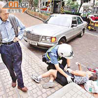 救護員為受傷老婦檢查，司機在旁助查。