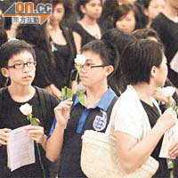 出席追思會的師生，手持白玫瑰。