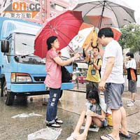 熱心夫婦為受傷女童打傘擋雨。