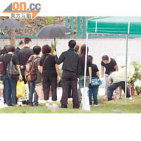 家人目送傅卓仁的靈柩入土落葬。