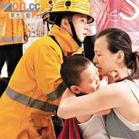 男童被夾手指，母親哄著由消防員搶救。