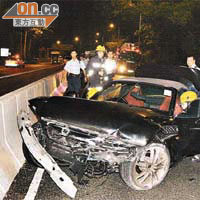 肇事跑車車頭損毀，警員及消防員在場調查。