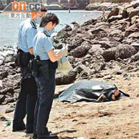港大生的屍體被撈起，用膠布覆蓋暫放泳灘，警員到場調查。