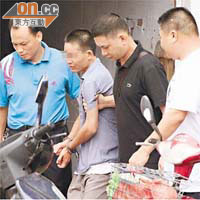 姓文疑兇（左二）由刑警押解到兇案現場。