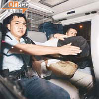其中一名埋女嬰的青年被警員蒙頭押返警署。	高偉明攝