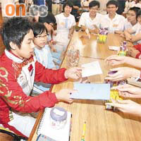 鄒凱(左)出席活動時不停為fans簽名。