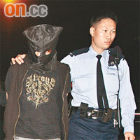 其中一名被捕青年由警員帶走調查。